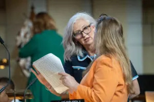  State Sen. Tanya Storer of Whitman, center, talks with State Sen. Wendy DeBoer of Omaha. April 10, 2025. (Zach Wendling/Nebraska Examiner)