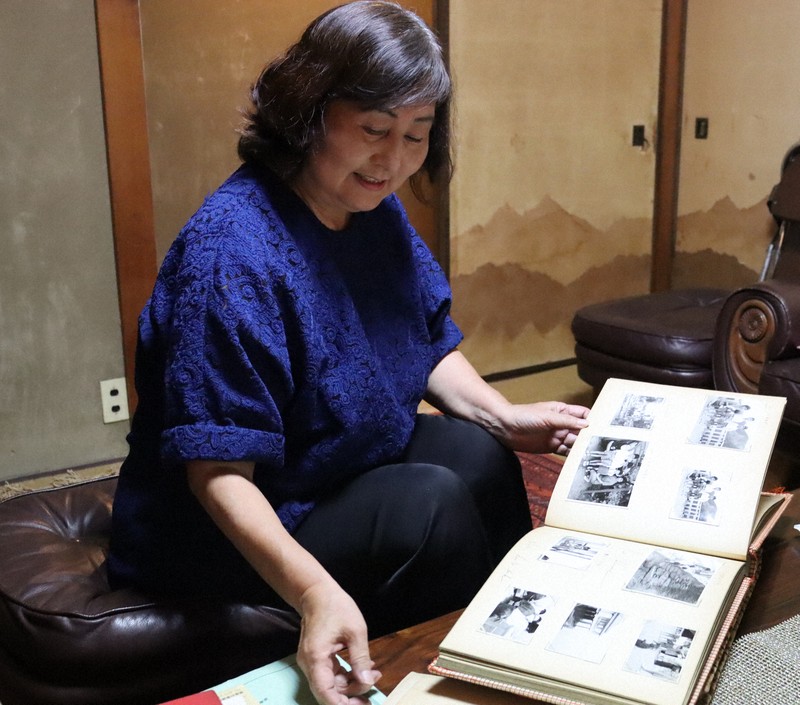 母の加口嘉子さんのアルバムをめくる敦子さん=京都市で2025年7月28日午後3時28分、木谷郁佳撮影