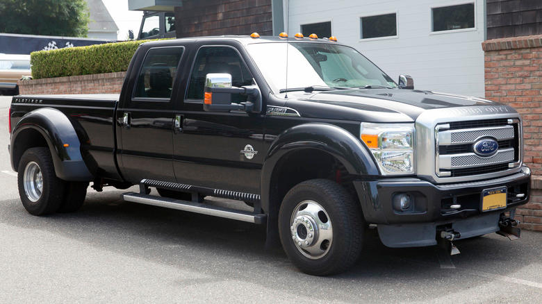 Tuxedo black metallic 2014 Ford F-450 Super Duty Crew Cab Platinum parked on a paved surface