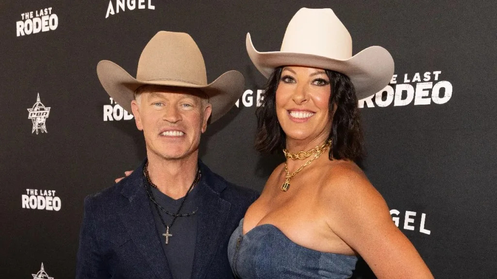 Actor Neal McDonough and wife Ruvé pose in front of a backdrop for Angel Studios' "The Last Rodeo" wearing cowboy hats
