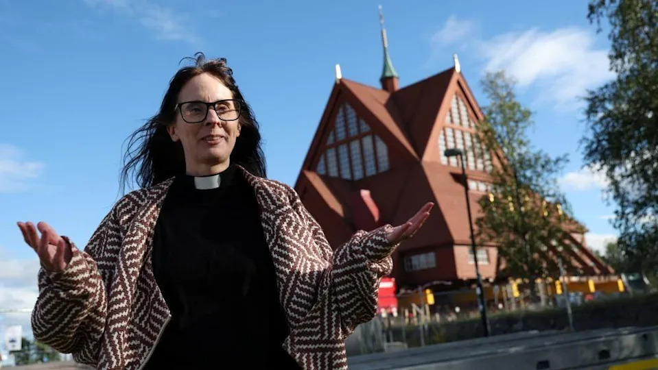 Pastor Lena Tjarnberg, speaks during an interview in front of Kiruna's historic wooden church, before it is moved to its new site 
