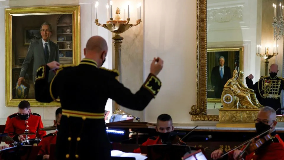 Former President George W. Bush's White House portrait is seen at left, as members of the US Marine Band play holiday music during a press tour of White House Christmas decorations in November 2021. - Jonathan Ernst/Reuters/File