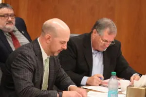  Justin Kringstad, executive director of the North Dakota Pipeline Authority, and Agriculture Commissioner Doug Goehring listen to discussion about two pipeline project proposals during the Aug. 21, 2025, meeting of the North Dakota Industrial Commission. (Photo by Mary Steurer/North Dakota Monitor)