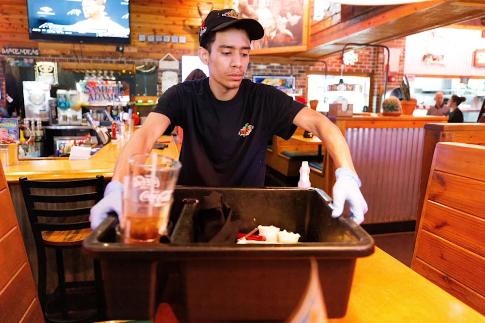 Dekari Henderson, an employee at Texas Roadhouse, cleans off tables on Wednesday, June 11, 2025, in South Bend.