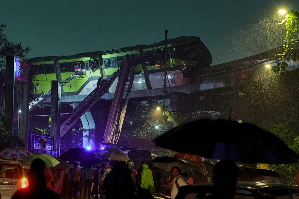 Rescue crews use extended ladders to reach people stranded on stuck monorail cars.