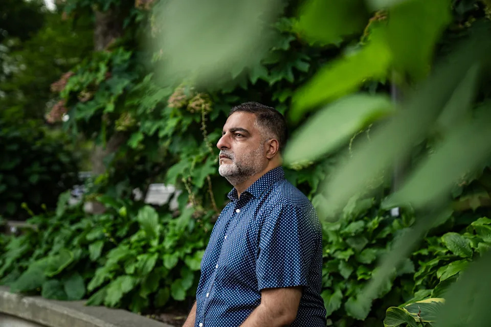 Hussein Rashid sits outside nears bushes (Vanessa Leroy / NBC News)