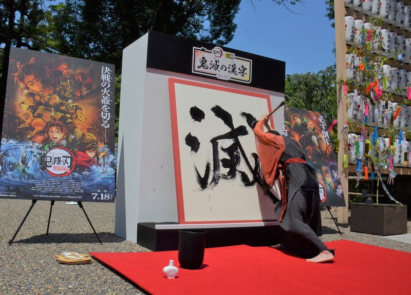 ダイナミックに「滅」の一字を揮毫する書家の川尾朋子さん＝京都市上京区で2025年7月30日午前11時9分、大東祐紀撮影