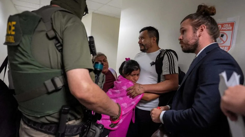 A migrant is embraced by his daughter as he is informed he is going to be detained by federal immigration officers at immigration court in Manhattan on July 31. - David Dee Delgado/Reuters
