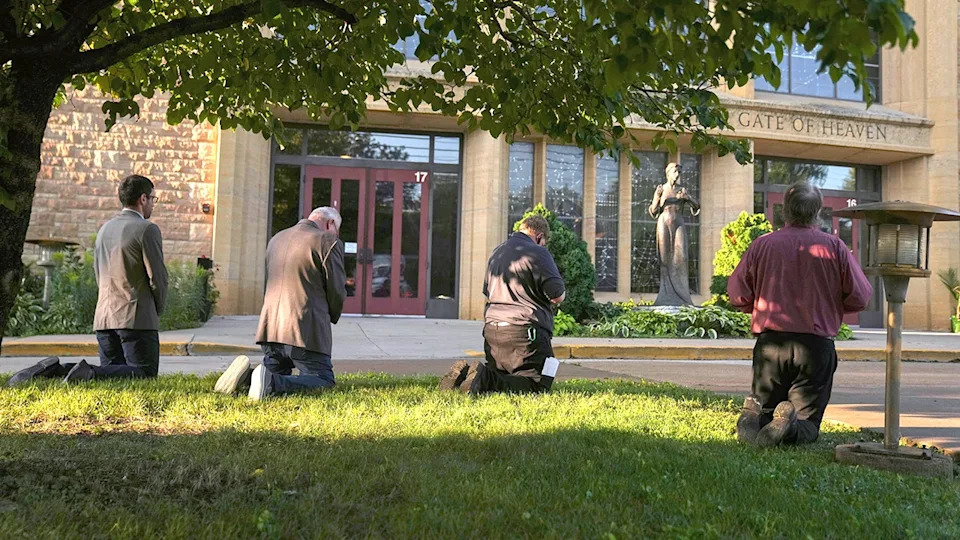 Mourners visit a memorial set up for victims of the mass school shooting at a Catholic school church.