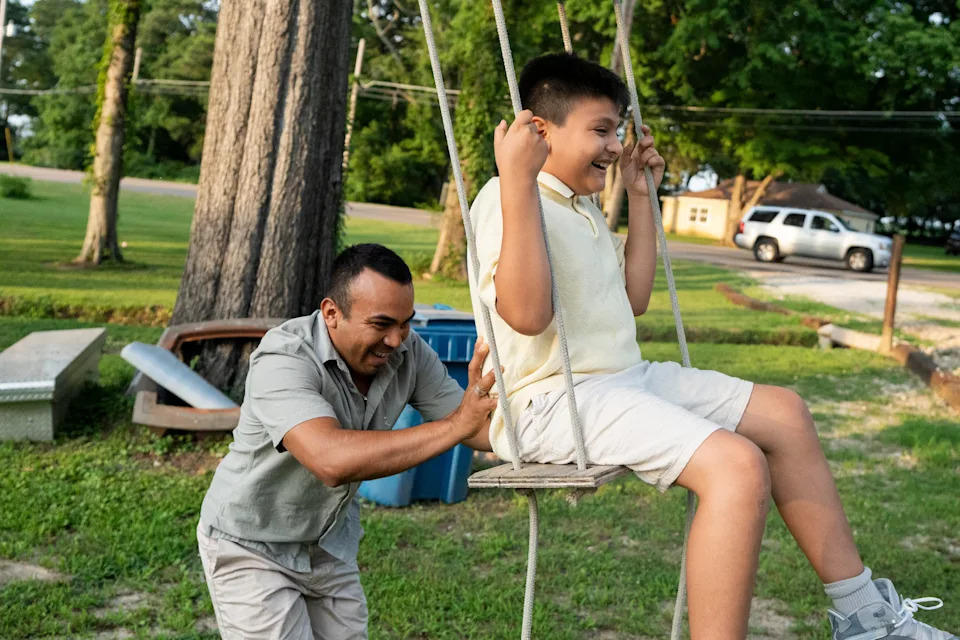 Raul Merida pushes his son Emiliano, 10, on a swing he set up in his front yard in Millington, Tenn., on June 27, 2025.