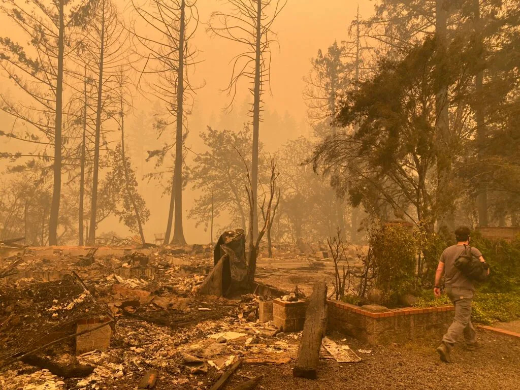 Sam Drevo stands next to the burned foundation of his mother's home in Gates following the 2020 Labor Day fires.
