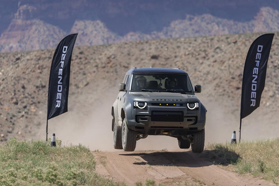 suv catches air as it rises above a dirt road
