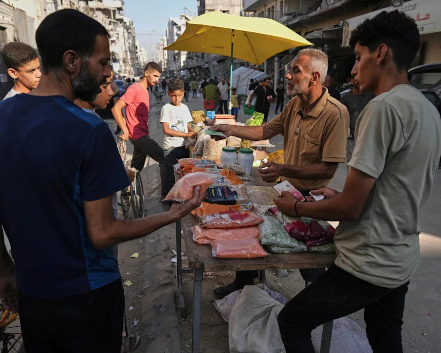 <span>A Palestinian vendor displays goods for sale at a street market in Gaza City.</span><span>Photograph: Jehad Alshrafi/AP</span>