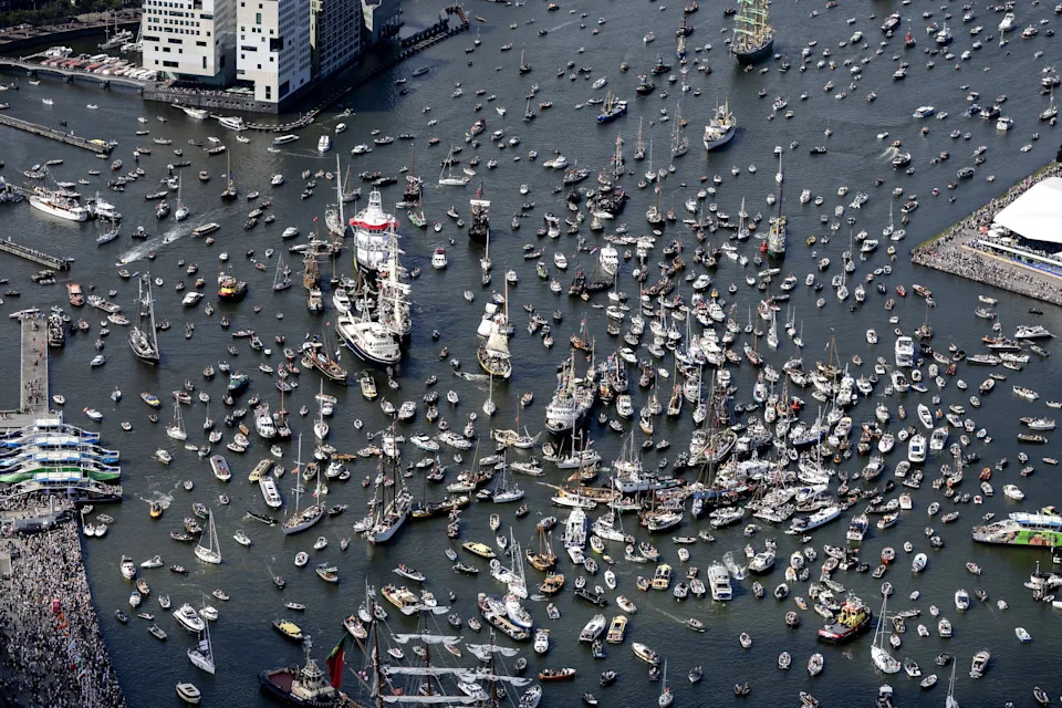 An aerial view of many boats and ships of all sizes crowded into a harbor.