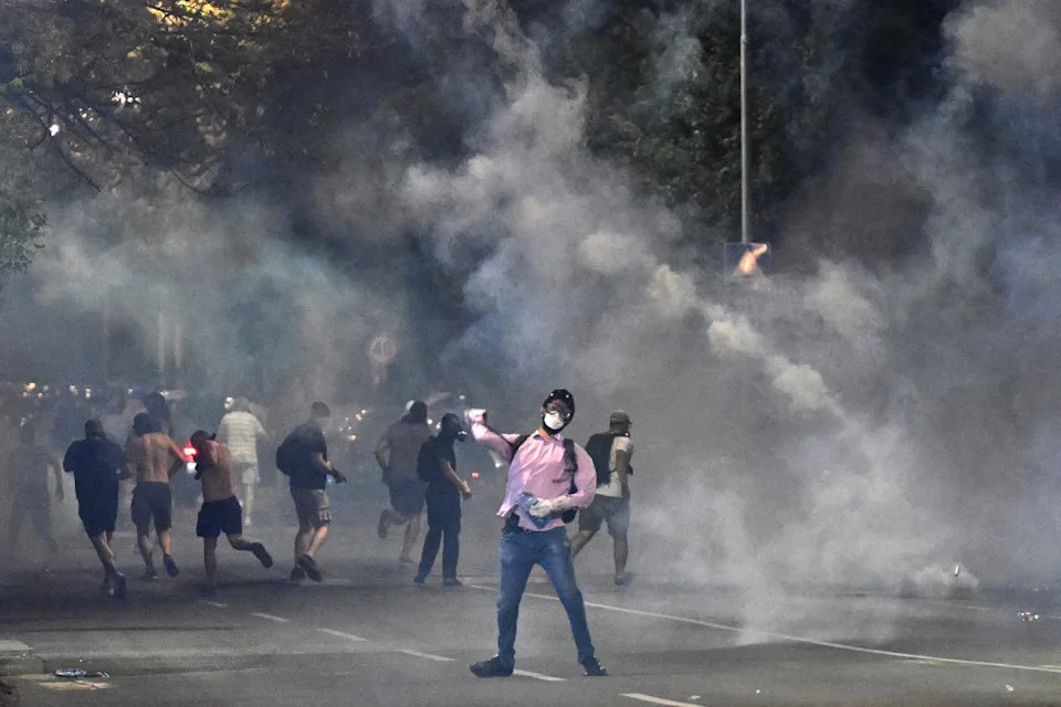 Demonstrators stand in clouds of tear gas during anti-government protests in Belgrade on August 16.