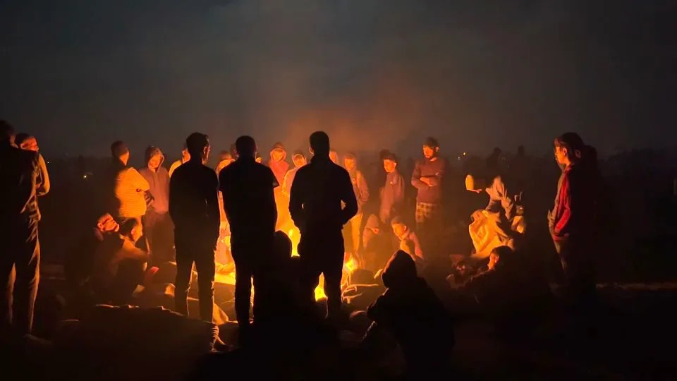 Thousands of people wait overnight for aid trucks to pass. Only a few women can be spotted among the crowds. - Tareq Al Hilou/CNN