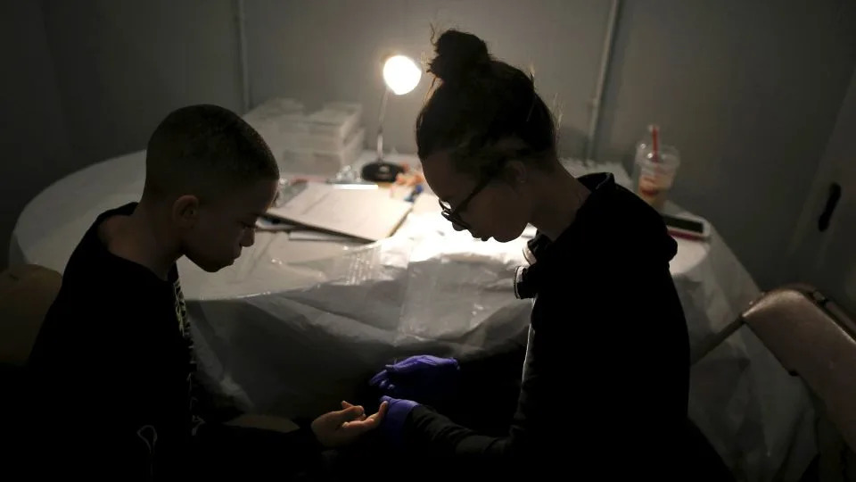 Brandon Fant, left, gets his blood tested for lead levels by Lashae Campbell at a clinic in Flint, Michigan, on March 6, 2016. - Jim Young/Reuters
