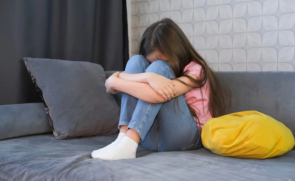 Young woman upset with her head in her hands.