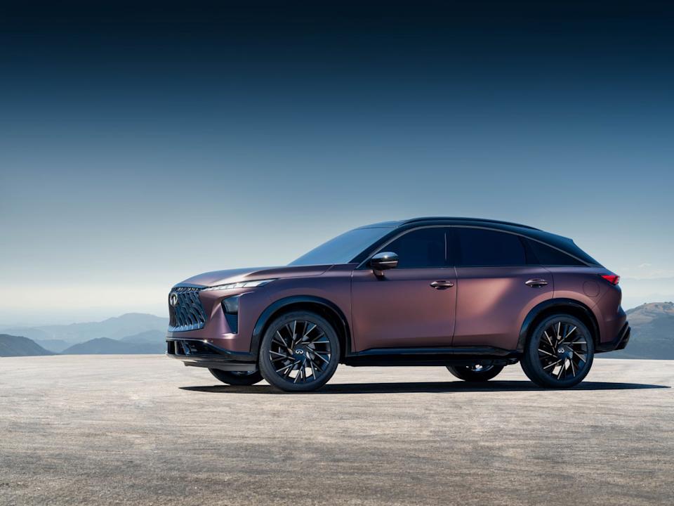 side profile view of bronze suv parked on concrete surface with mountains in background.