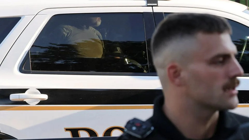 A US Secret Service Uniformed Division officer detains a man that burned a US flag at the edge of Lafayette Park, across from the White House, on Monday. - Jonathan Ernst/Reuters