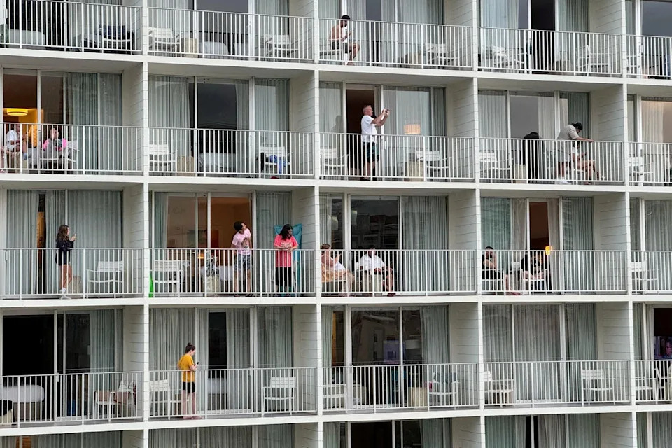 Vacationers stand on balconies at the 'Alohilani Resort looking towards Waikiki Beach after authorities warned of the possibility of a tsunami (REUTERS)