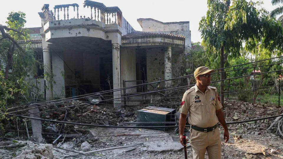 An Indian police officer stands outside a house that was damaged by overnight Pakistani artillery shelling in Jammu, India-administered Kashmir, on May 10. - Rakesh Bakshi/AFP/Getty Images
