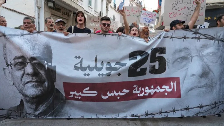 Demonstrators display a banner as protesters rally against Tunisian President Kais Saied on the fourth anniversary of his power grab, in Tunis, Tunisia, July 25, 2025. Demonstrators denounced Saied’s rule as authoritarian, calling the country an