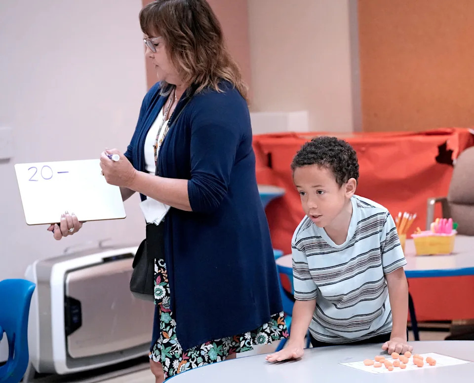Elm Creative Arts teacher Sheryl Wartman does a math assignment with former first-graders including Emerson, 7, right, during summer school at the Milwaukee school.