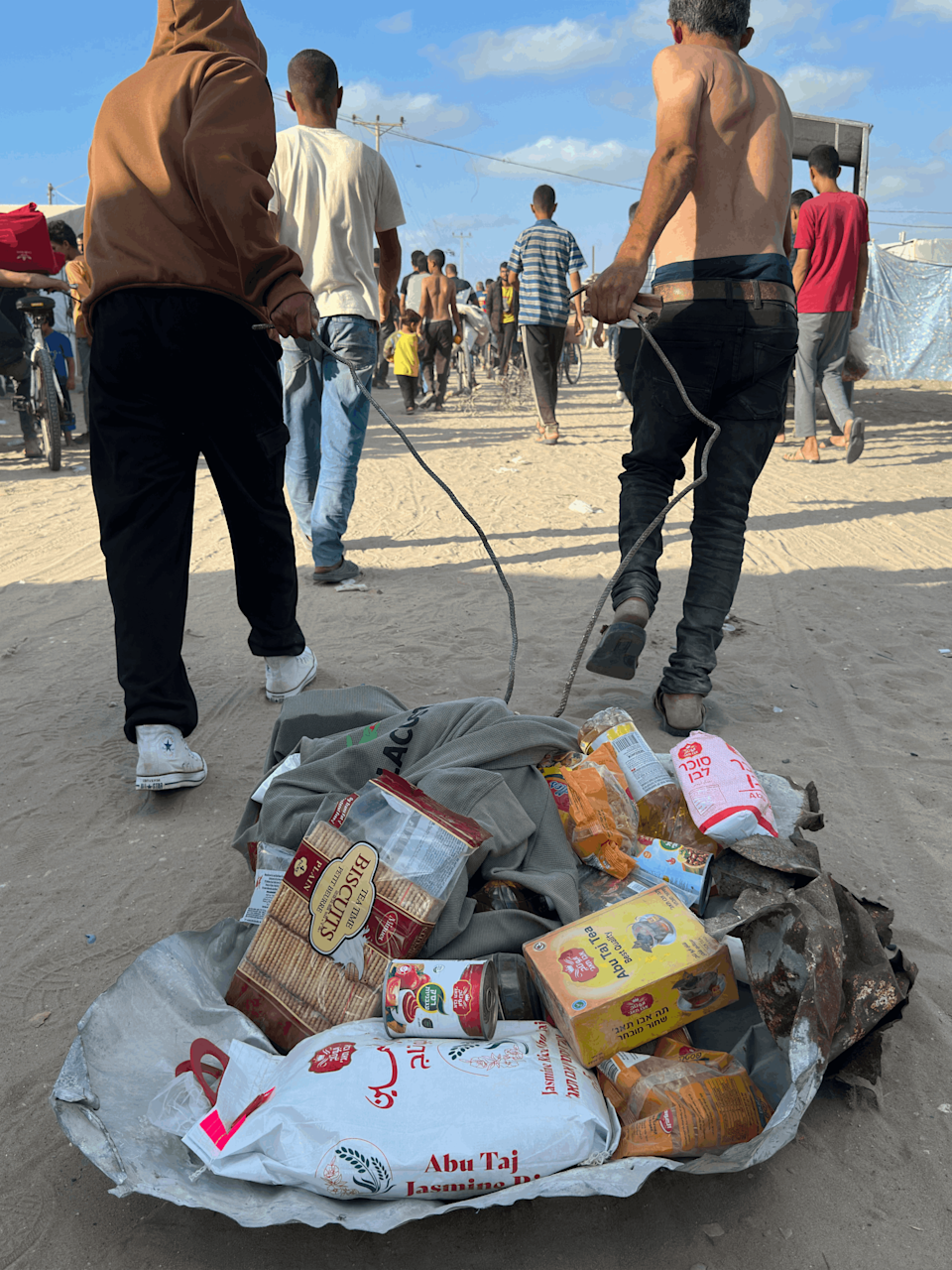 Dos hombres arrastran alimentos de una de las cajas de la FHG.