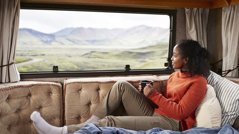 Young woman relaxing inside an RV staring out the window