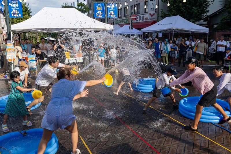 埼玉県熊谷市で暑さ対策イベントとして開催された「打ち水大作戦」=2024年8月11日(一般社団法人アツいまち提供)