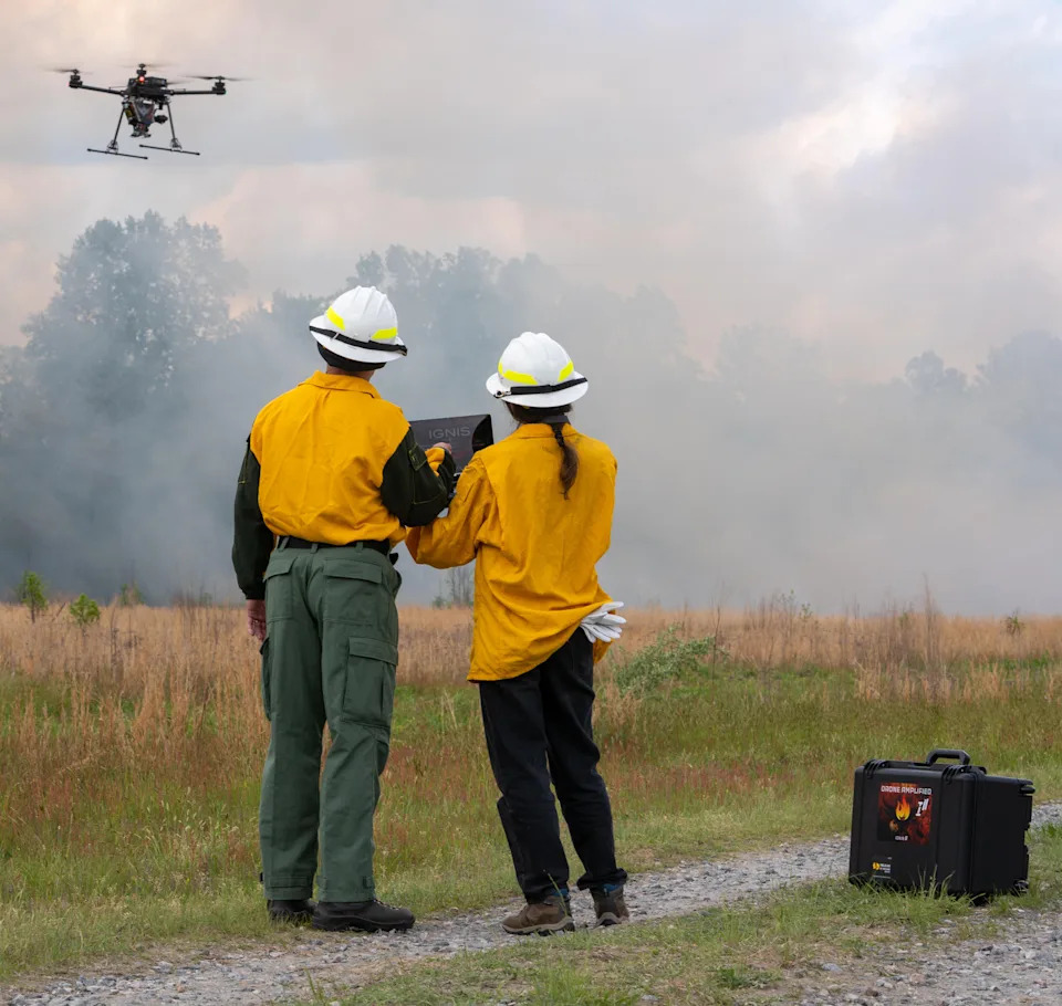 two people operate a drone in smoky setting