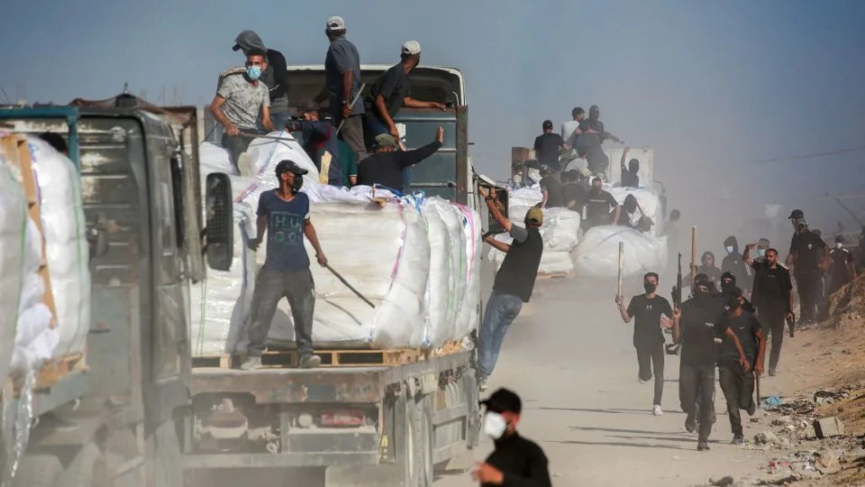 Members of Palestinian families who have organized to prevent theft guard trucks carrying aid which entered the Gaza Strip from the Israeli-controlled Zikim crossing on June 25. - Bashar Taleb/AFP/Getty Images/File