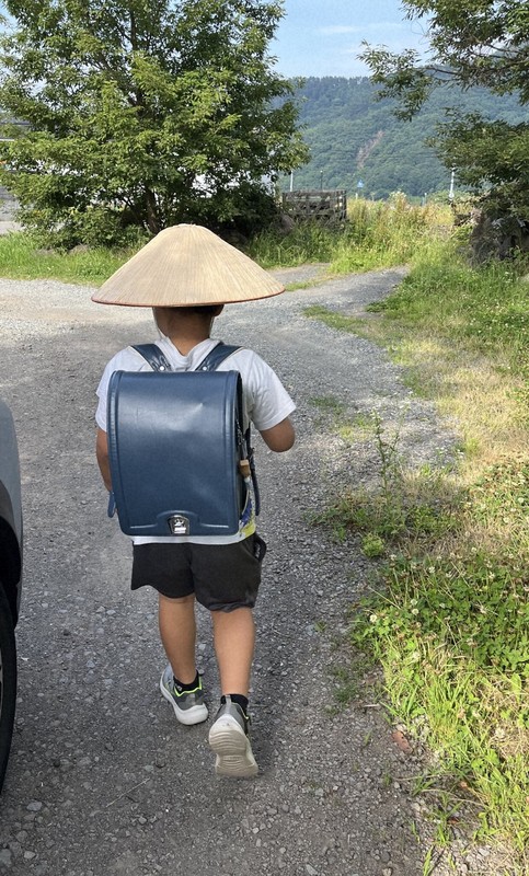 X（ツイッター）で話題になった、かさをかぶって登校する小学生＝エビふらいさん提供