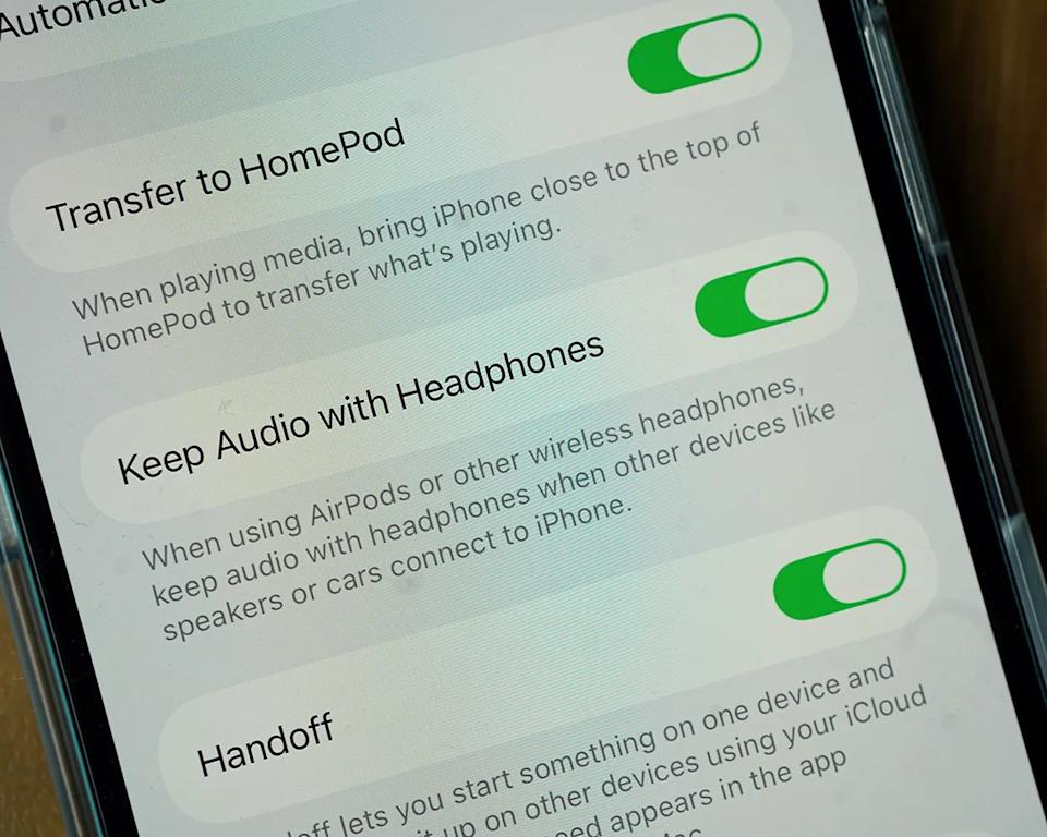 Settings screen on an iPhone showing three toggled-on options: "Transfer to HomePod," "Keep Audio with Headphones," and "Handoff." Each option has a brief description underneath explaining its function.