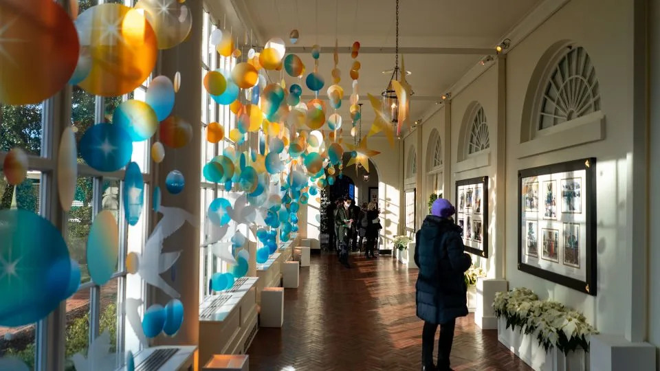 In this December 2021 photo, people make their way through the East Colonnade of the East Wing of the White House in Washington, DC. - Kent Nishimura/The Los Angeles Times/Getty Images