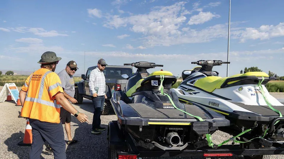 Watercraft inspector Mark Klug, left, inspects two jet skis last used in Nevada at a watercraft boat inspection station in Marsing, Friday, July 25, 2025.