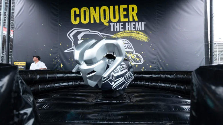 The ram mechanical bull ride surrounded by black inflatable protective material andwith the word "conquer the hemi" in the background