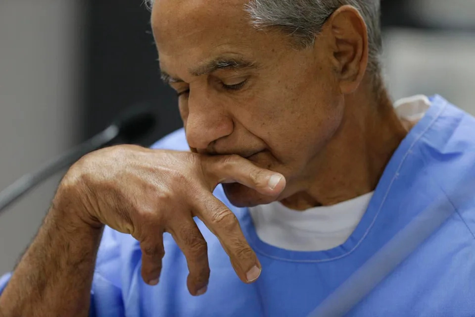 Sirhan Sirhan closes his eyes and holds a finger to his mouth.