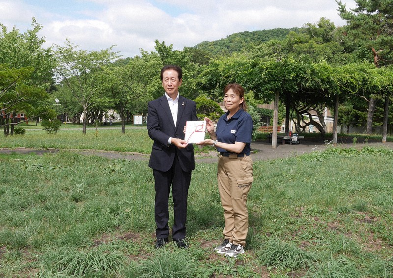 西岡建設の加藤健一社長(左)から氷の目録を受け取る円山動物園の白水(しろうず)彩園長=札幌市中央区で2025年8月5日午後2時49分、水戸健一撮影