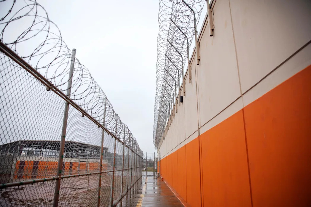 <span>Barbed wire lines a recreation area at the Stewart Detention Center, in Lumpkin, Georgia.</span><span>Photograph: David Goldman/AP</span>