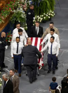 Detective Caleb Martinez, Jesus Estrada, Alejandro Estrada, Hermilo Molina, Hazel Pena, and Isai Pena escort Tremonton-Garland police officer Eric Estrada’s casket out of Utah State University’s Dee Glen Smith Spectrum Arena on Thursday, Aug. 28, 2025. (Photo by Dayton Call for Utah News Dispatch)