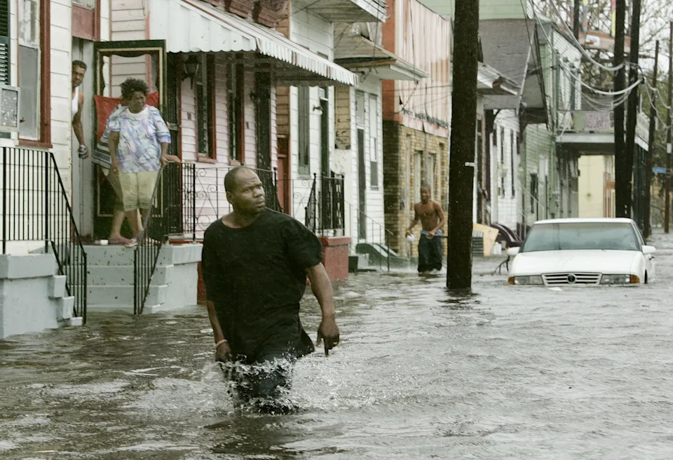 People come out of their homes to a flooded street after Hurricane Katrina hit the area with heavy wind and rain August 29, 2005 in New Orleans, Louisiana. Katrina was down graded to a category 4 storm as it approached New Orleans.