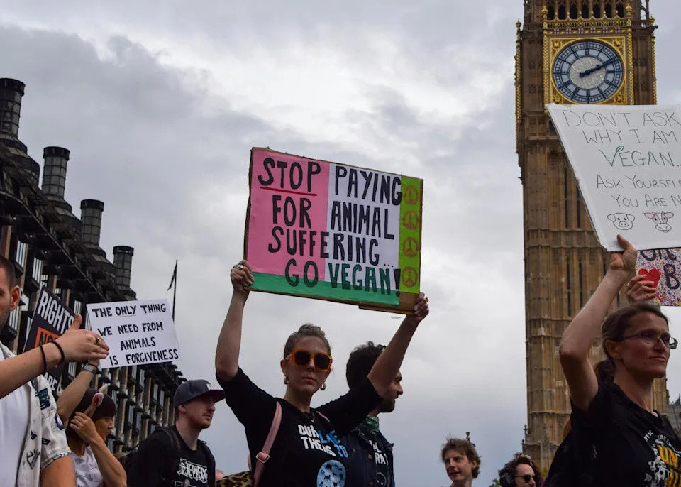 a woman in a crowd holds a sign over her head