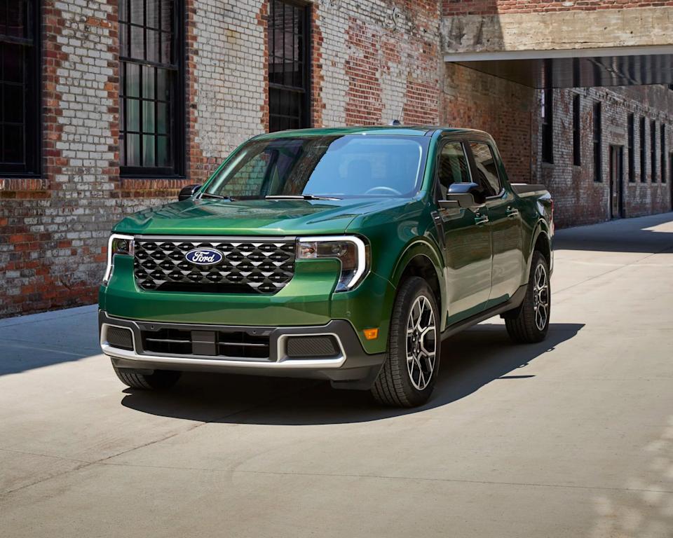 a photo of a green ford maverick pickup truck in an urban environment