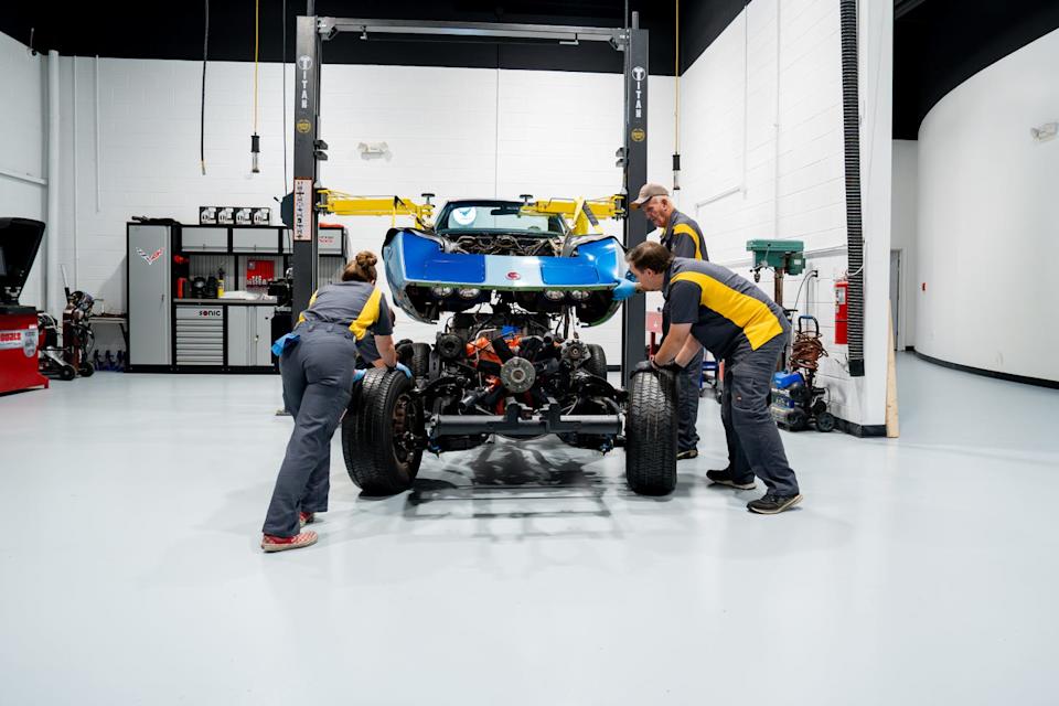 mechanics working on a partially assembled car in an auto workshop at national corvette museum