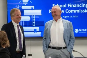  Nebraska Treasurer Tom Briese of Albion, left, and Dave Murman of Glenvil, chair of the Legislature’s Education Committee, talk during a break of a School Financing Review Commission meeting. Aug. 12, 2025. (Zach Wendling/Nebraska Examiner)