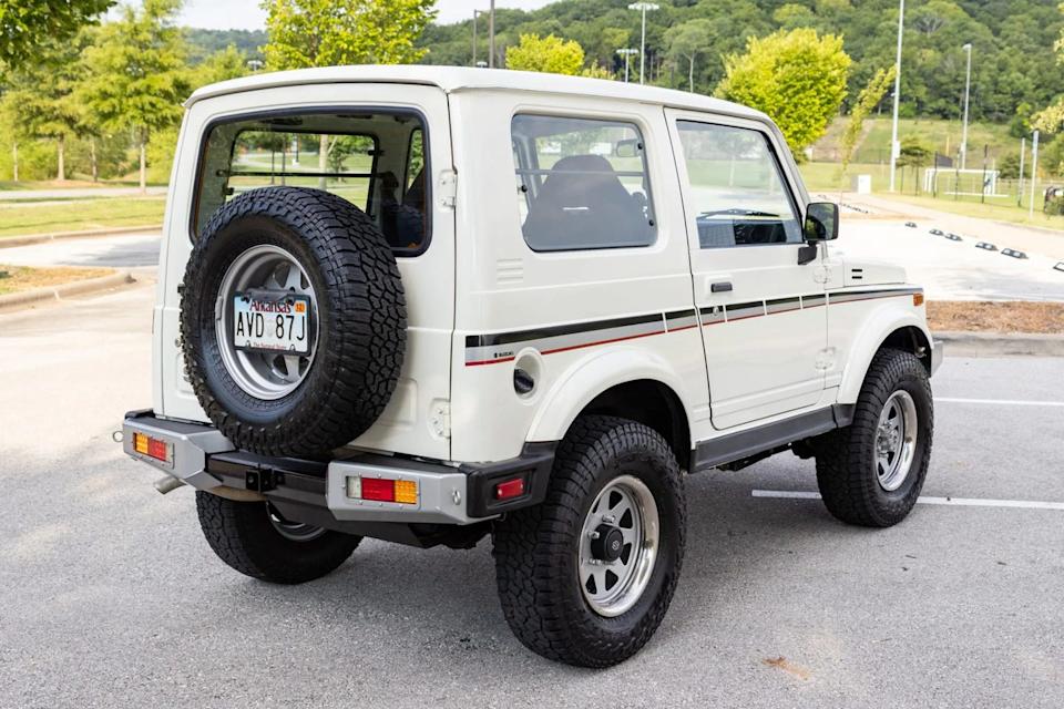 rear three quarter view of white two door suv with full size spare tire and arkansas license plate.