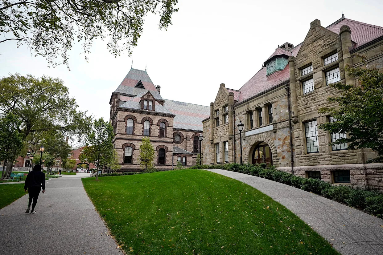 A passer-by walks along a path on the campus of Brown University (Steven Senne / AP file)