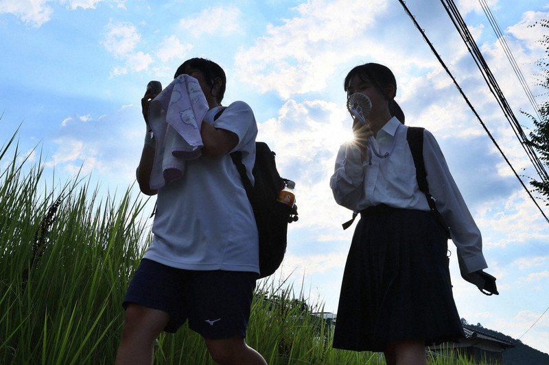 国内観測史上最高気温となる41.2℃を記録。暑さの中、扇風機を手に下校する高校生たち＝兵庫県丹波市で2025年7月30日午後4時32分、長澤凜太郎撮影